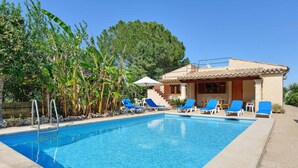 A swimming pool with lounge chairs, a building with a tiled roof, and surrounding greenery. - MAGDALENA, traditional villa near the town. (Pollensa)