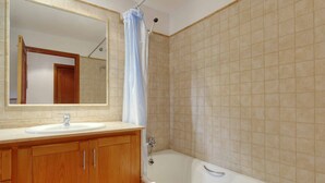 A bathroom with a bathtub, a sink, a mirror, and wooden cabinets. - MAGDALENA, traditional villa near the town. (Pollensa)