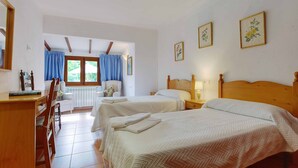 A hotel room with two beds, a desk, a chair, a window with curtains, and framed botanical prints on the wall. - MAGDALENA, traditional villa near the town. (Pollensa)