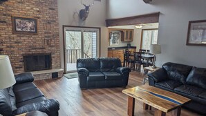 A spacious living room with leather sofas, a wooden coffee table, and a fireplace. - Escape to Serenity at The Covered Bridge Hideaway-The Perfect Vacation Rental!
 (Fennimore)