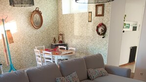 Sala de estar com sofá seccional, mesa de centro e área de jantar com cadeiras e mesa.