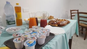 A table with food items, drinks, and Parmalat yogurt cups. - Idilliaco Inn (Motta Sant'Anastasia)