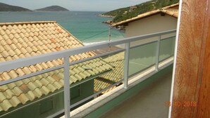 A balcony with a view of the sea and a distant island.