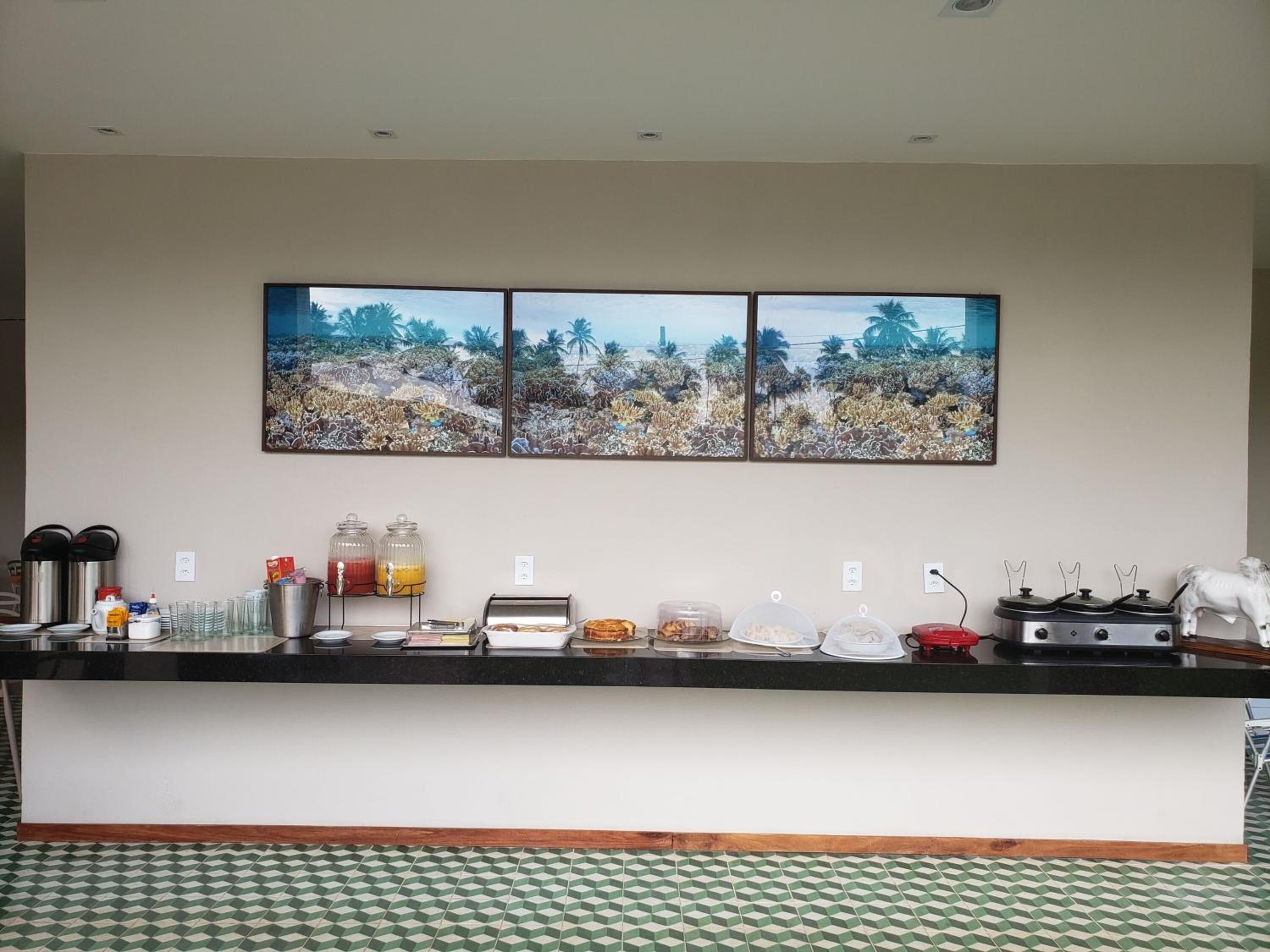 A hotel kitchen with a buffet setup, including a coffee station, juice dispensers, and a stove.