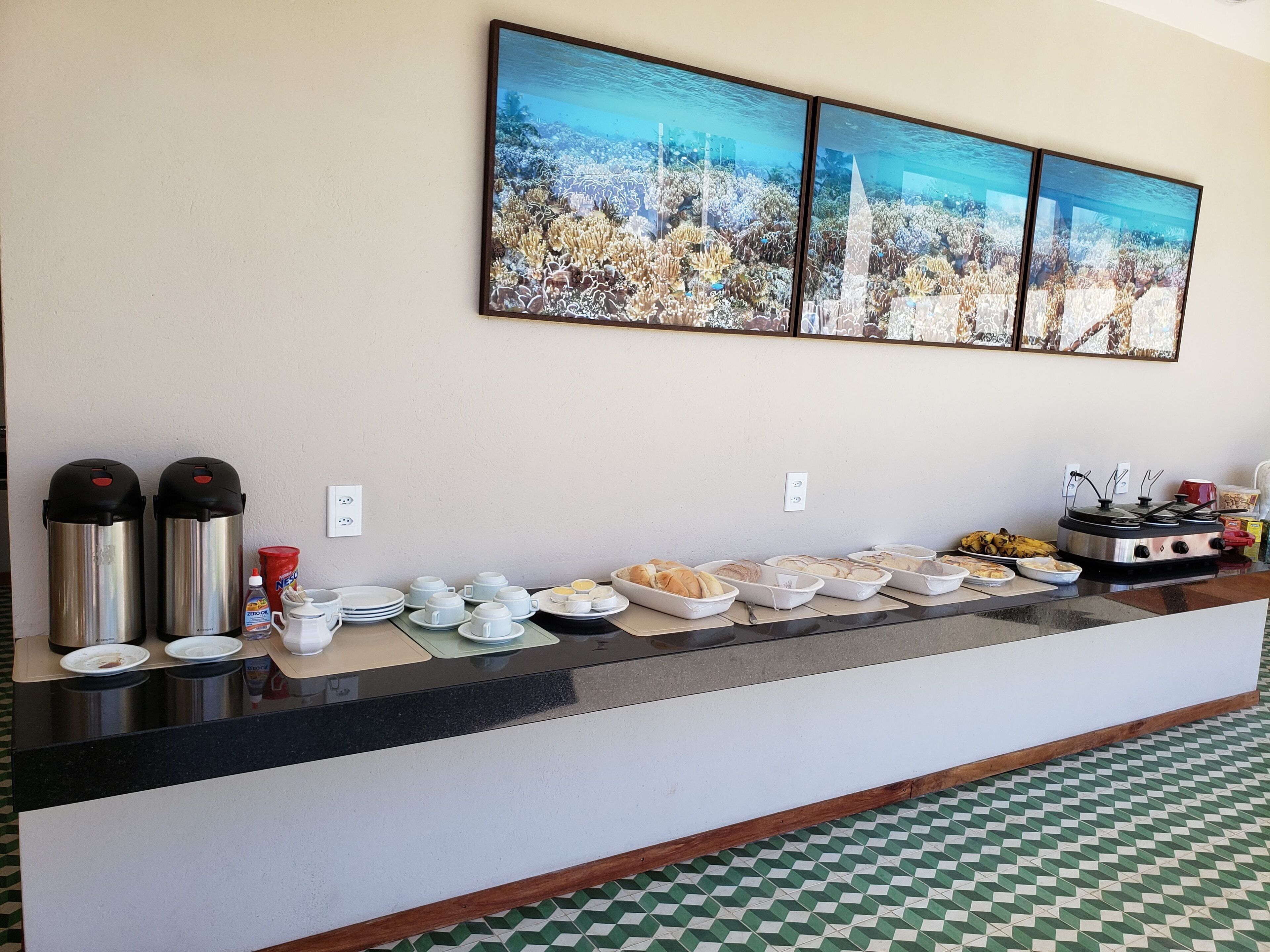 A buffet setup with various food items and condiments, a coffee machine, and a stove.