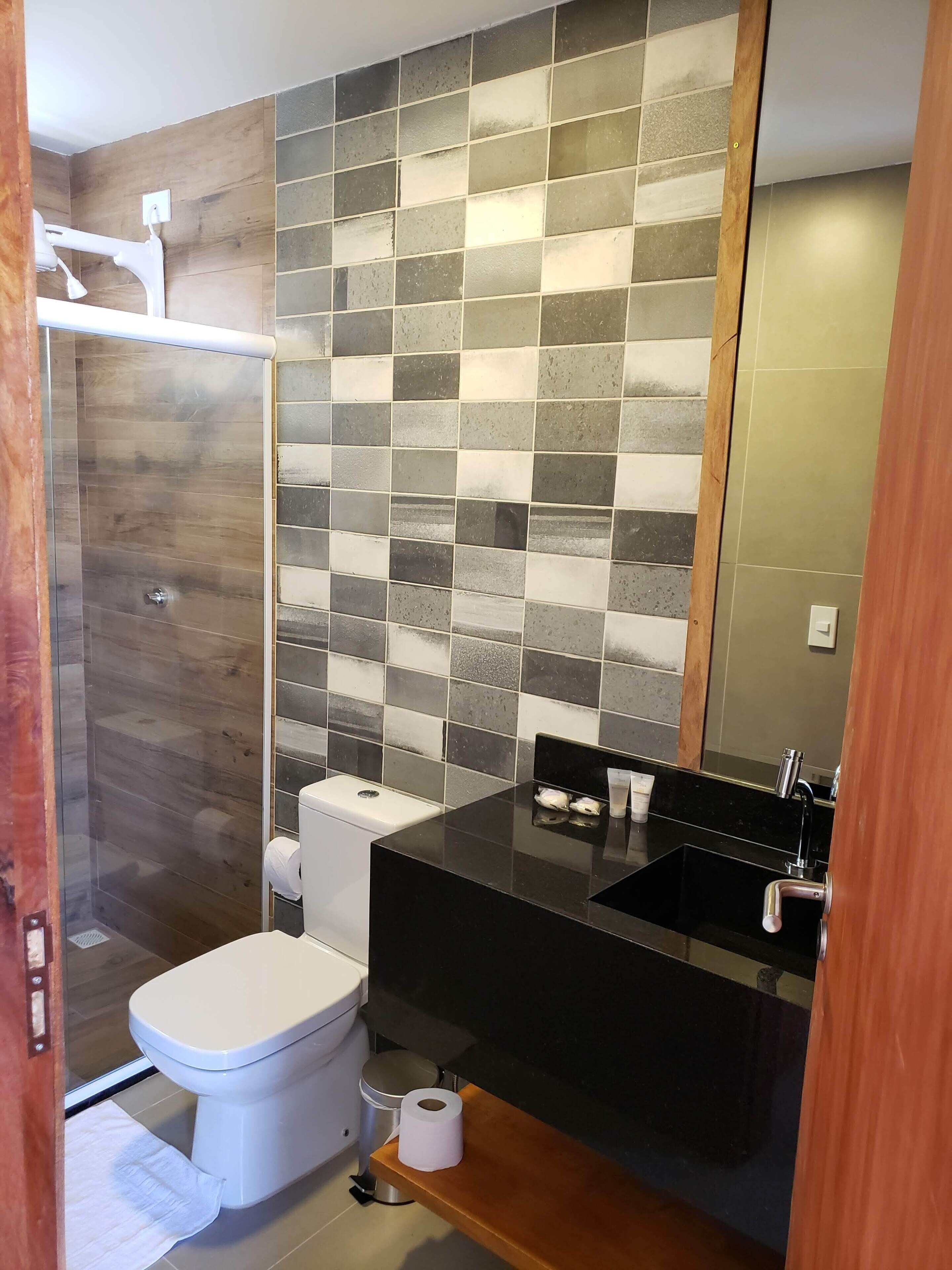 A bathroom with a shower, toilet, and sink.