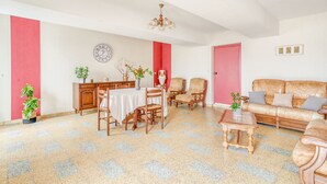 Ein Essbereich mit Tisch, Stühlen, einer Couch und einer Kandelaber.