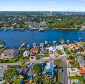 An aerial view of a residential area with houses, docks, and a large body of water. - Anchors Away (Panama City Beach)