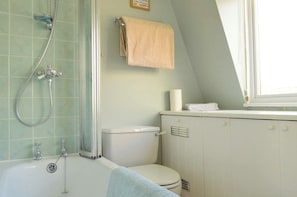 A bathroom with a shower, toilet, and a towel rack.