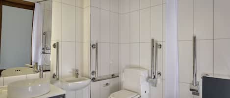 A modern bathroom with a toilet, sink, and shower.