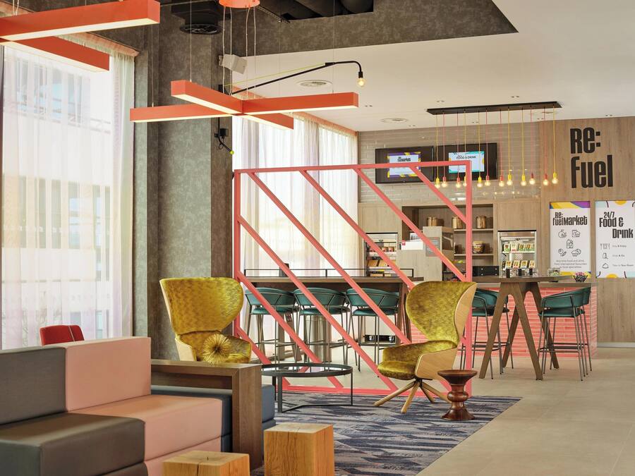 Un interior moderno con una zona de bar, asientos y un ventanal grande.