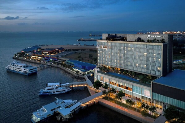 A waterfront Marriott hotel with multiple buildings, a marina with yachts, and a view of the ocean. - Batam Marriott Hotel Harbour Bay (Batam)