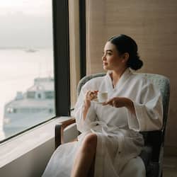 Relax in a serene room with a stunning water view, comfortable seating, and elegant touches.