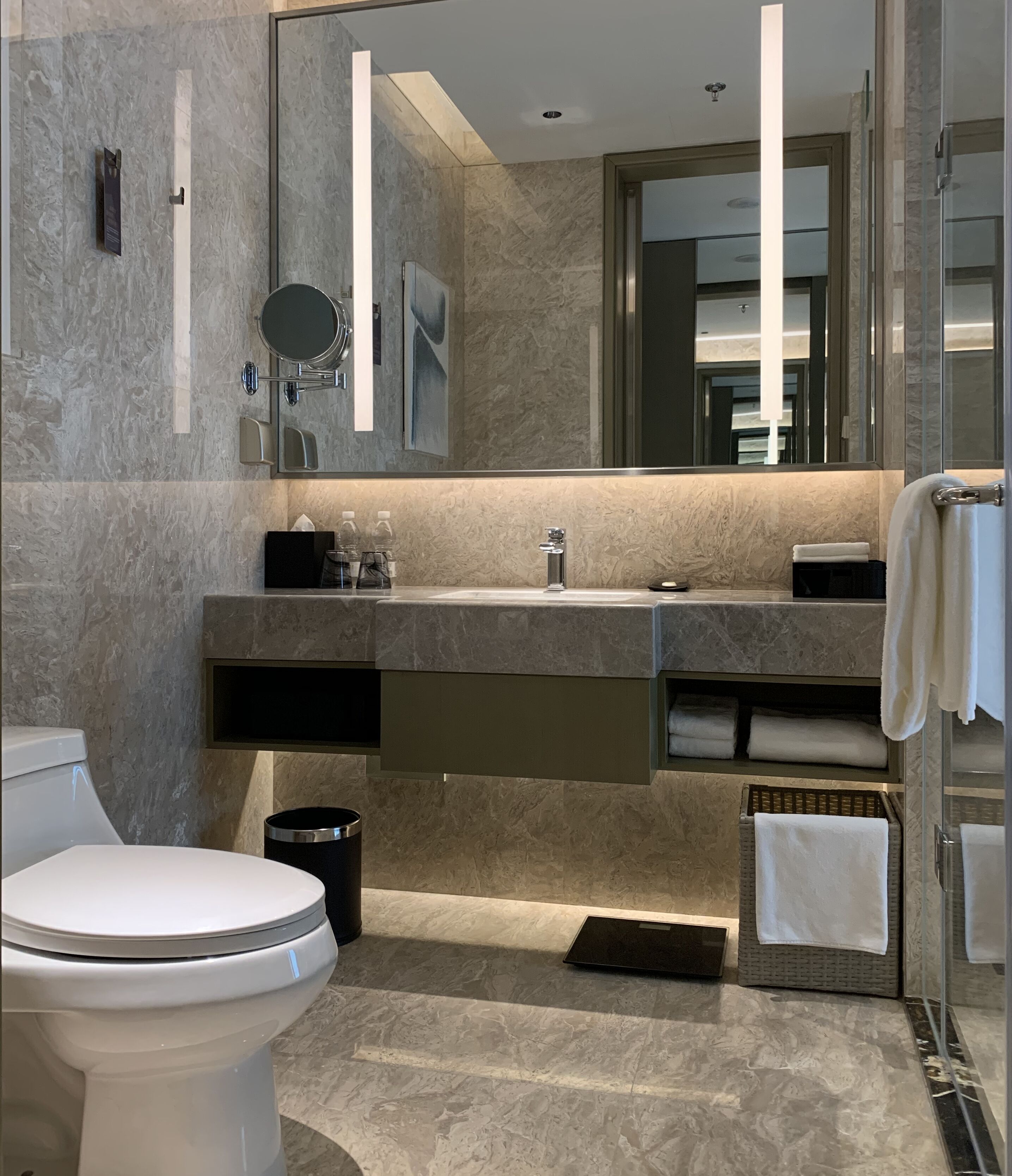 Ein modernes Badezimmer mit Toilette, Waschbecken und Spiegel.