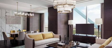 Quarto de hotel moderno com uma janela grande, um sofá, uma mesa de jantar e um candelabro.