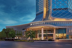 Um hotel JW Marriott com design moderno, apresentando fachada curva e grandes janelas de vidro.
