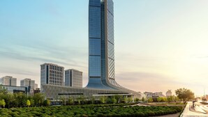 Un moderno rascacielos con un diseño curvo distintivo, rodeado de abundante vegetación y otros edificios contemporáneos.