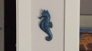 A vertical arrangement of three decorative items: an octopus, a scallop shell, and a seahorse. - Casa Bolle (Sicilia)