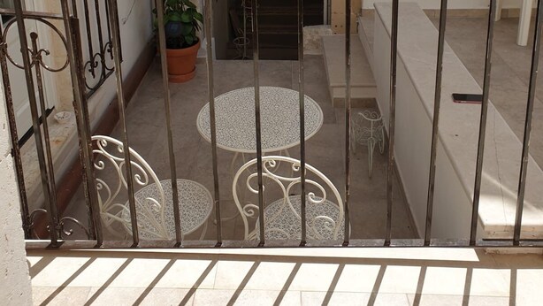 A courtyard with a stone fireplace, potted plants, and a tiled floor. - Casa Bolle (Sicilia)