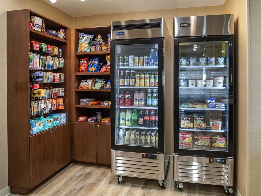 A self-service beverage station with refrigerated drink dispensers and snack shelves.