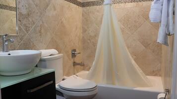 A bathroom with a sink, toilet, and bathtub.