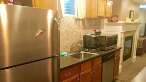 A kitchen with stainless steel appliances, wooden cabinets, a microwave, and a coffee maker. - Comfortable Apartment in Northwest Omaha (Omaha)