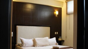 A hotel room with a large bed, dark headboard, and a bedside lamp. - Posada Vista Tepoz (Tepoztlán)