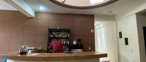 A circular bar area with stools, a counter, and a tiled floor.