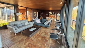 A modern living room with two sofas, a coffee table, and a dining area with chairs and a table.