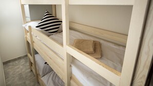 Een stapelbed met een gestreept kussen en een opgevouwen handdoek op het bovenste bed.