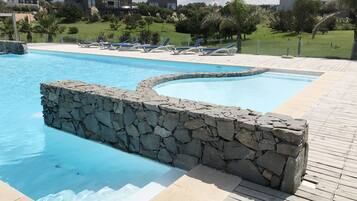 Una piscina al aire libre, una piscina climatizada