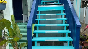 Una escala amb baranes blaves que condueix a una porta.