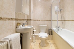 Un baño moderno con lavamanos, inodoro y bañera.