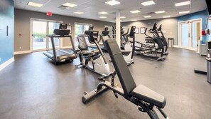 A gym with treadmills, elliptical machines, and weight machines.