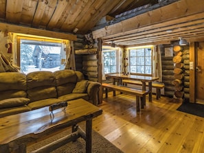 A log cabin interior with a sofa, wooden benches, and a table. - Kelokota by Interhome (Salla)