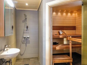 A modern bathroom with a shower, a sink, and a sauna. - Peurakumpu by Interhome (Inari)