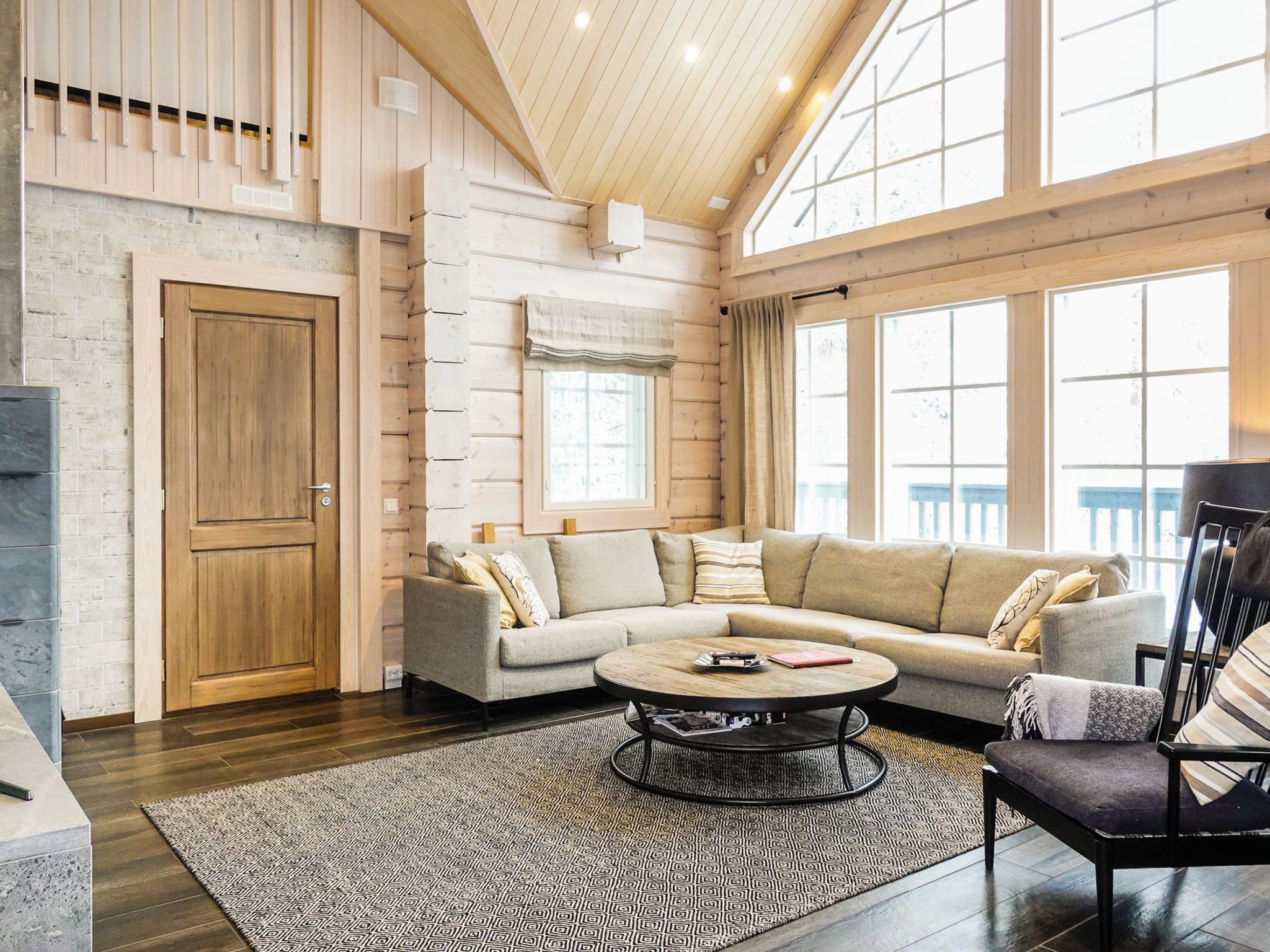 A spacious living room with a large sectional sofa, a coffee table, and a fireplace.