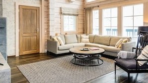 A spacious living room with a large window, a wooden ceiling, and a cozy sofa set. - Peurakumpu by Interhome (Inari)