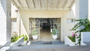 A building entrance with a metal gate, a concrete staircase, and potted plants. - clean, comfy & quiet with views  (Tower Isle)