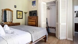 A bedroom with a bed, dresser, wardrobe, and a mirror. - clean, comfy & quiet with views  (Tower Isle)