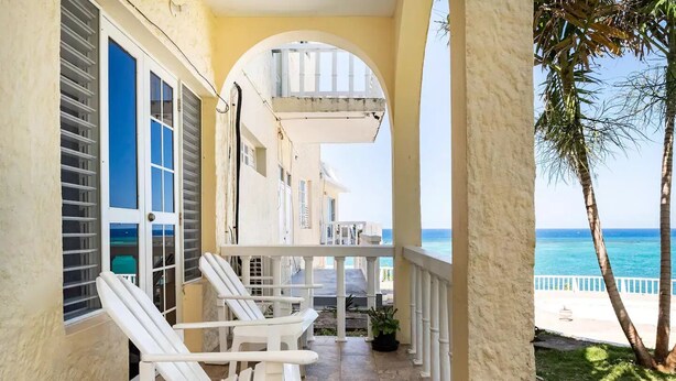 A covered outdoor area with white chairs and a view of the ocean. - clean, comfy & quiet with views  (Tower Isle)