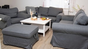 Un salon moderne avec des canapés gris et une table basse blanche.