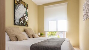 A bedroom with a bed, a window, a painting, and a plant. - Misterhost San Bernardo (Sevilla)
