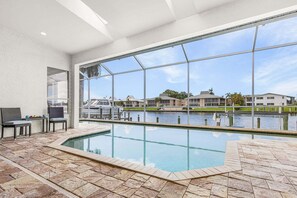Piscina con vista a un puerto deportivo y edificios.