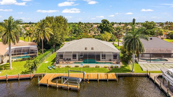 Una casa con piscina, muelle y vistas del barrio circundante.