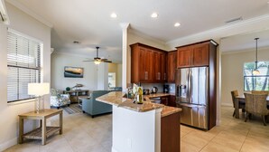 A modern kitchen with a central island, stainless steel appliances, and wooden cabinetry.