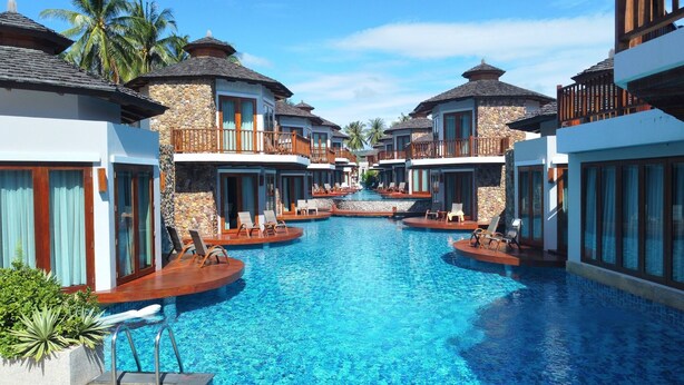 A resort with multiple swimming pools, each surrounded by lounge chairs and wooden decks. - Yotaka Khanom (Khanom)