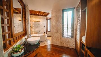 A modern bathroom with a freestanding bathtub, a large mirror, and a wooden floor.