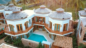A multi-story resort with a central pool, multiple balconies, and a tropical setting. - Yotaka Khanom (Khanom)
