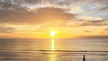 Tramonto sull'oceano con cielo sereno e acque calme.